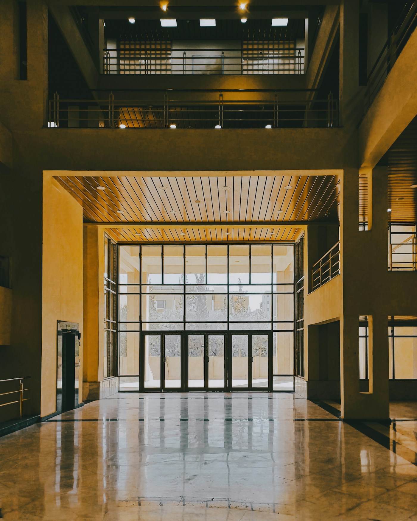 Illustrative glazed entrance doors in a warm architectural lobby